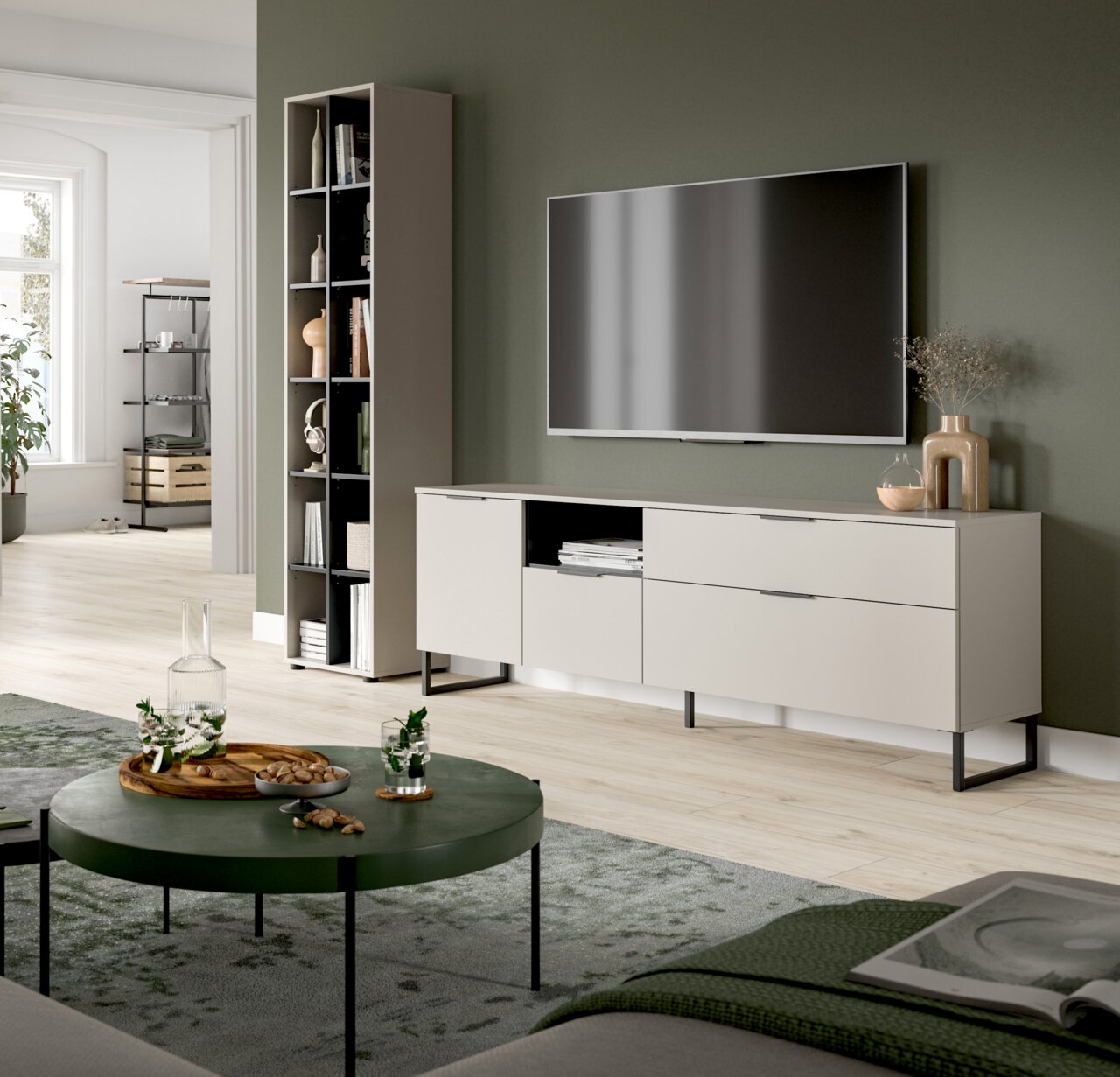 MID.YOU Wohnkombination NOIDA Modernes Wohnzimmer mit wandmontiertem Fernseher über einem hellgrauen TV-Lowboard auf schwarzen Metallfüßen, daneben hohes Regal; Perspektive: frontale, leicht seitliche Ansicht auf die TV-Wand.