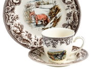 Porzellan-Teetasse mit Untertasse und passendem Teller, braunes florales Dekor und Tiermotive (Fuchs im Schnee, fliegende Enten), freigestellt auf Weiß, Frontansicht leicht von oben