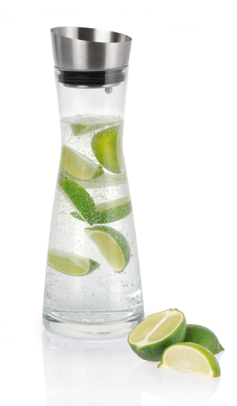 Wasserkaraffe mit Edelstahlverschluss, gefüllt mit sprudelndem Wasser und Limettenscheiben, seitliche Perspektive