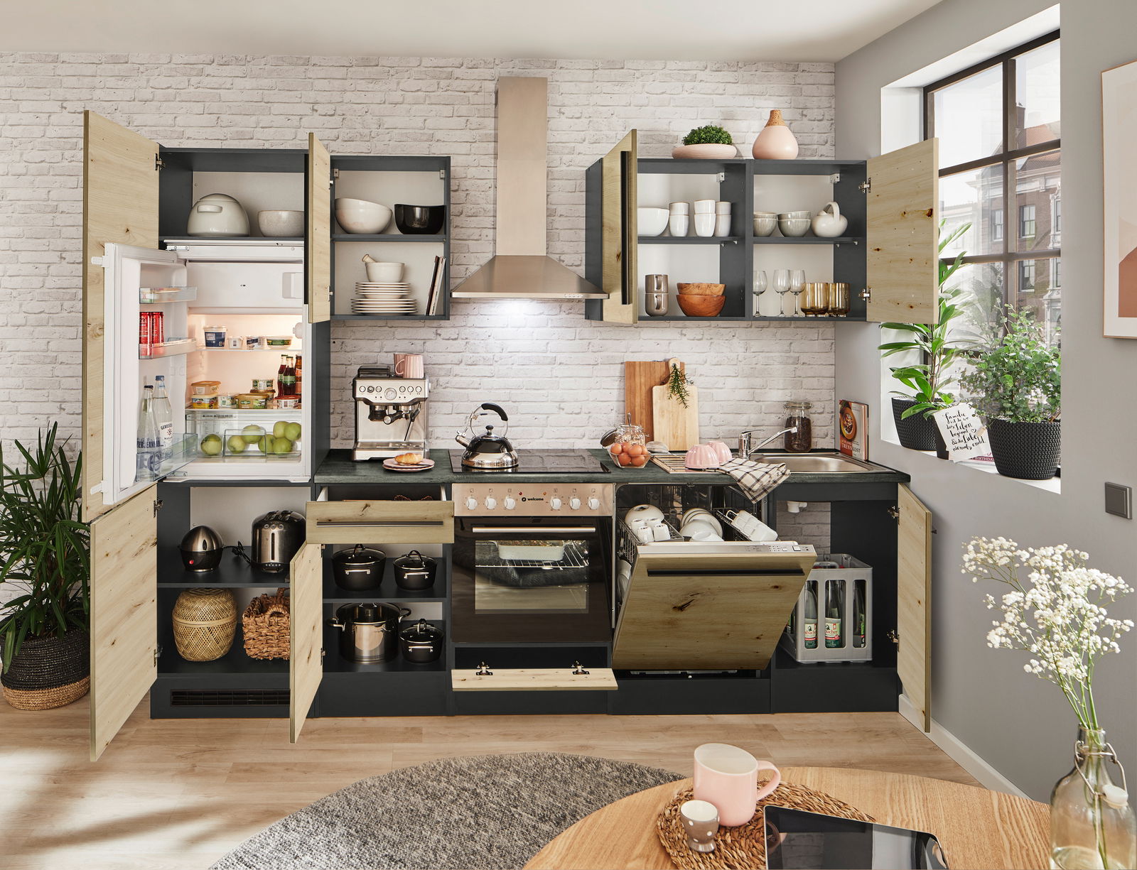 Moderne Küchenzeile mit offenen Schränken, Kühlschrank, Herd und Spüle, aus der Perspektive eines hellen, gemütlichen Raumes mit Pflanzen und Dekorationen.