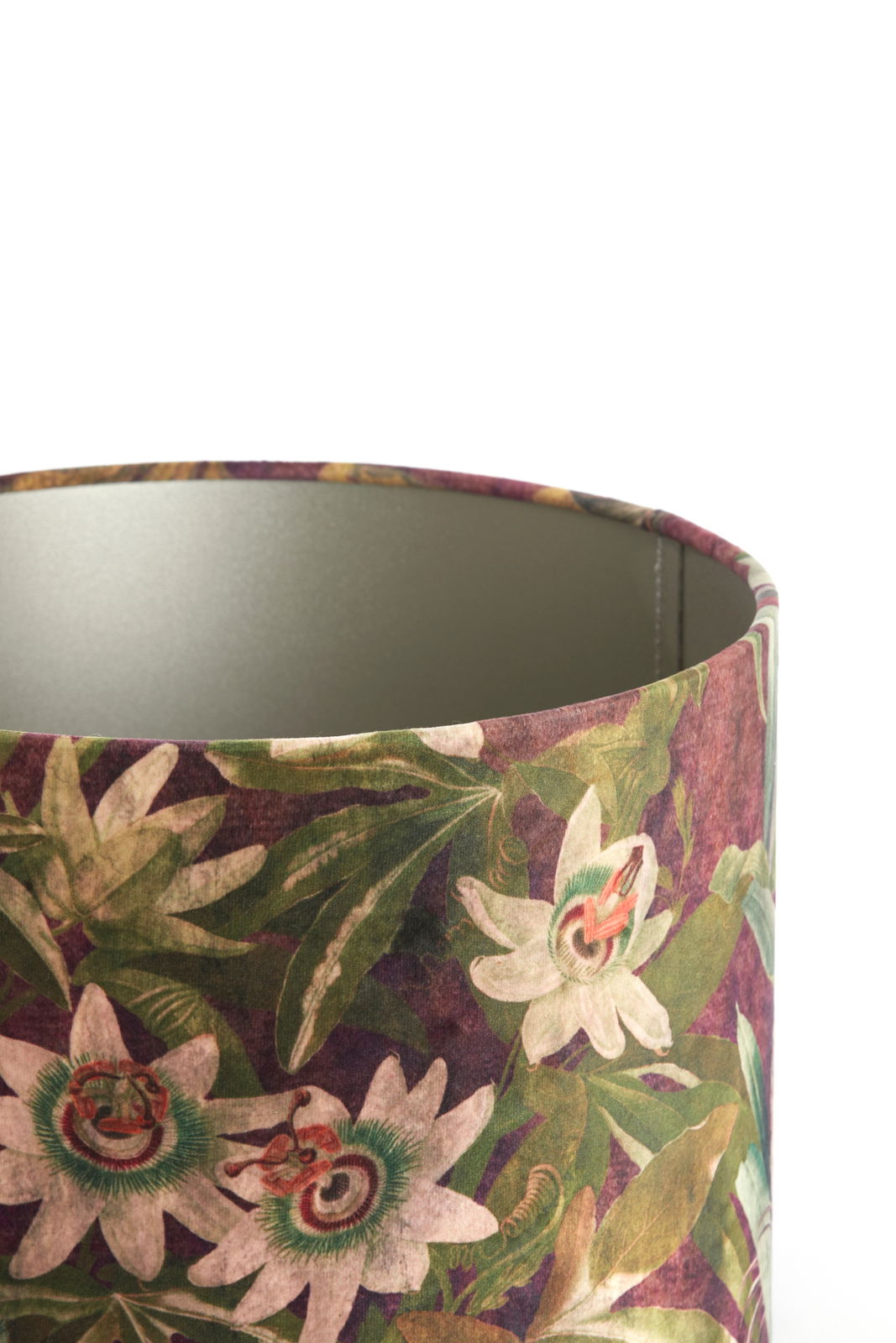 Zylindrischer Lampenschirm mit floralem Muster in Nahaufnahme, zeigt weiße Blumen und grüne Blätter auf einem dunklen Hintergrund.