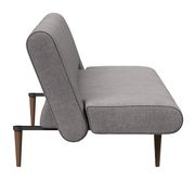 Seitenansicht eines grauen Funktionssofas mit Holzbeinen.