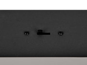 Nahaufnahme einer schwarzen Pendelleuchte mit Schrauben und Schalter, von unten betrachtet.