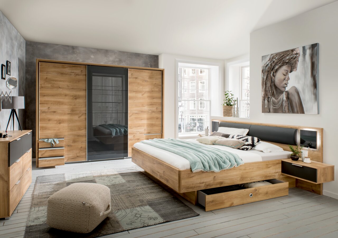 Moderne slaapkamer met een kast met schuifdeuren, een bedset en een ladekast in houtlook, gezien vanaf de zijkant.