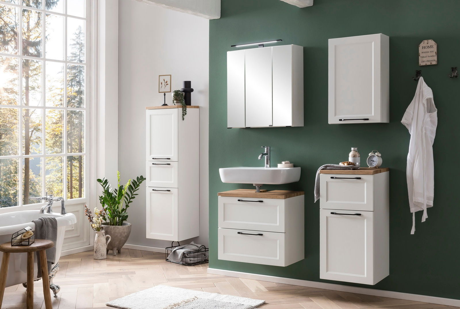 Moderner weißer Hängeschrank in einem stilvollen Badezimmer mit grüner Wand, aus der Perspektive von vorne betrachtet.