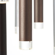 Nahaufnahme von hängenden, zylinderförmigen LED-Leuchten in verschiedenen Metalltönen mit klaren Endkappen, seitliche Perspektive