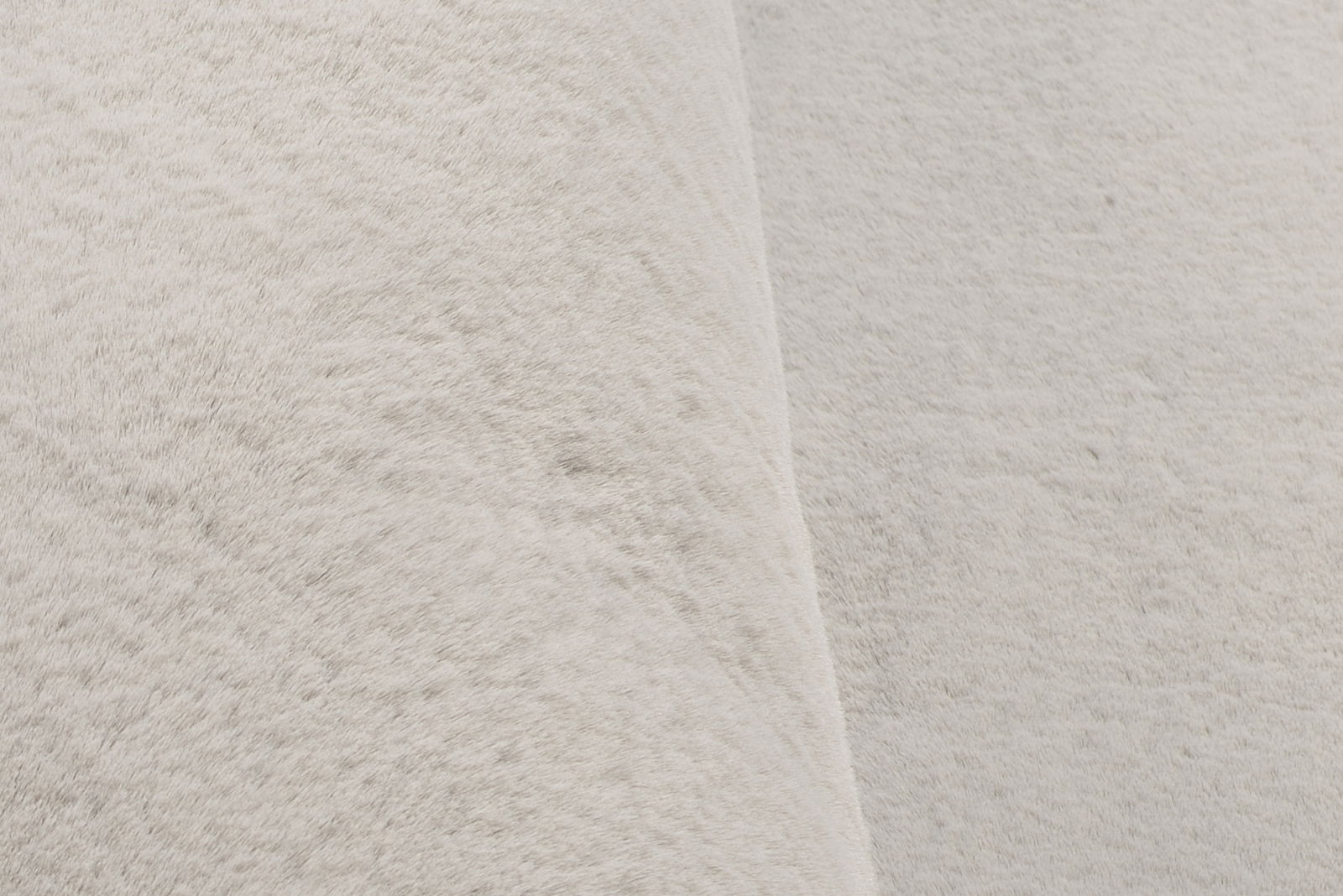 Nahaufnahme eines weißen Fellteppichs aus seitlicher Perspektive