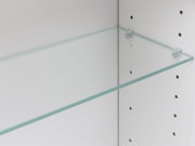 Transparenter Glasboden mit Halteclips in einem weißen Regal, Detailansicht aus schräger Seitenperspektive