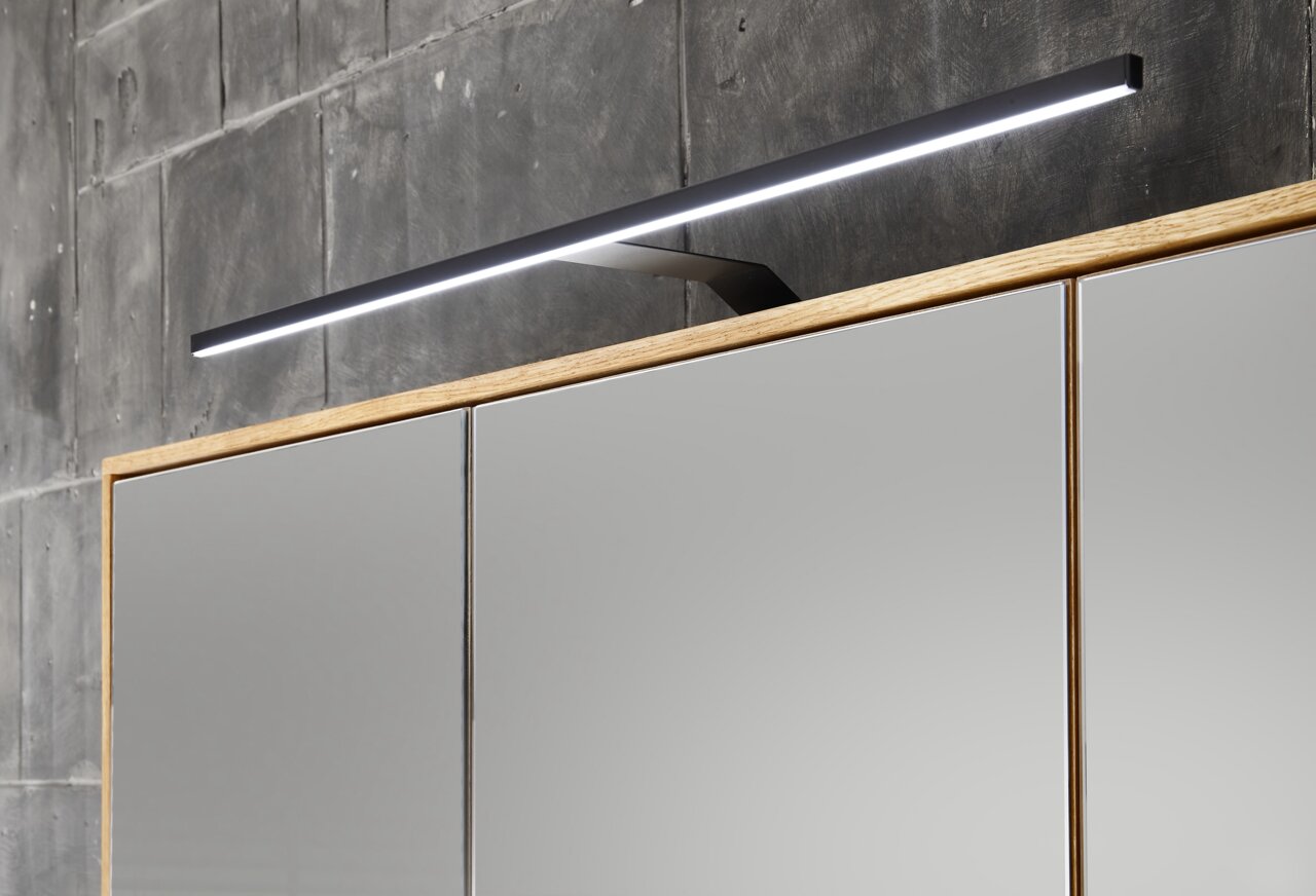 Moderner Spiegelschrank mit Holzrahmen und integrierter LED-Leuchte, seitliche Perspektive