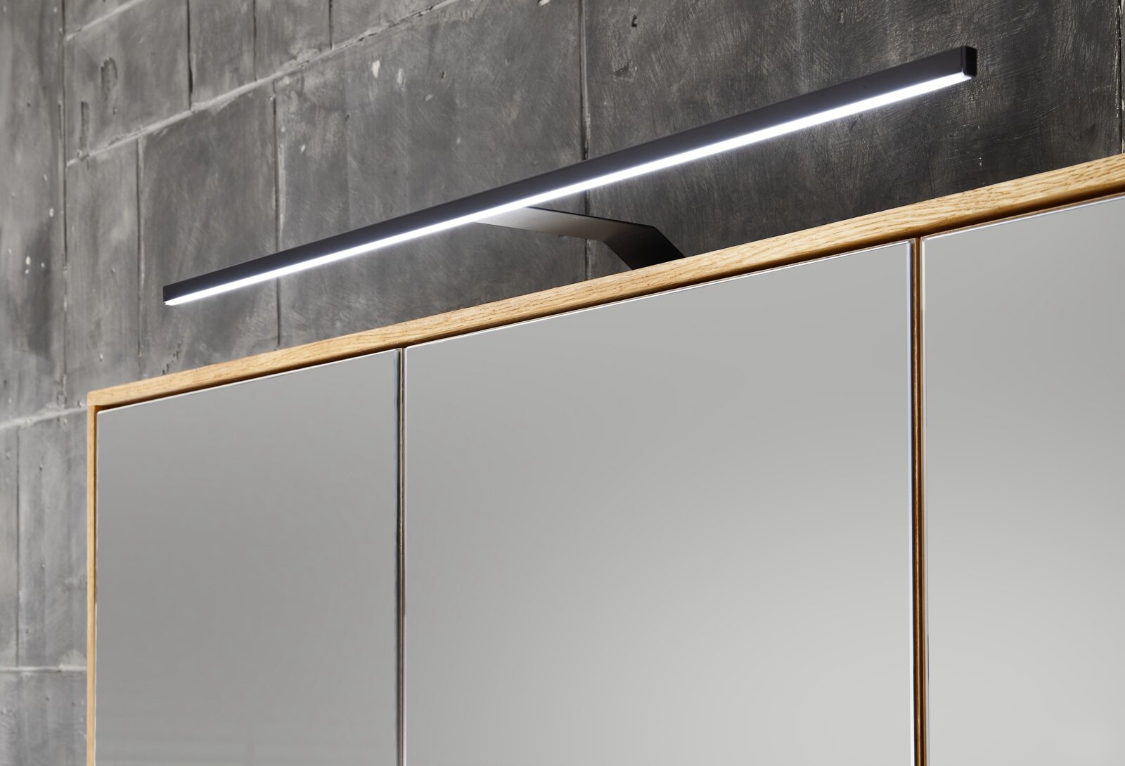 Moderner Spiegelschrank mit Holzrahmen und integrierter LED-Leuchte, seitliche Perspektive