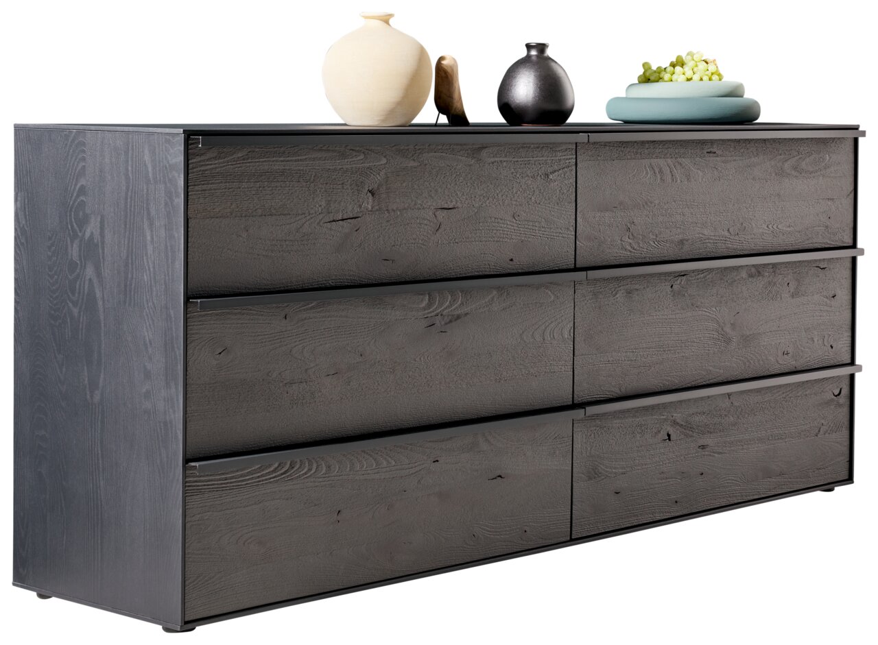 Modernes Sideboard aus dunklem Holz mit sechs Schubladen, dekoriert mit Vasen und Obst, seitliche Perspektive
