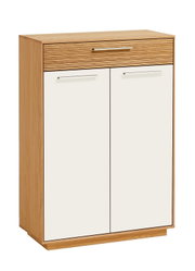 Hoher Holzschrank mit zwei weißen Türen, oberer Schublade in Holzoptik mit Rillenstruktur und Metallgriffen, freigestellt auf weißem Hintergrund, Frontansicht leicht von links