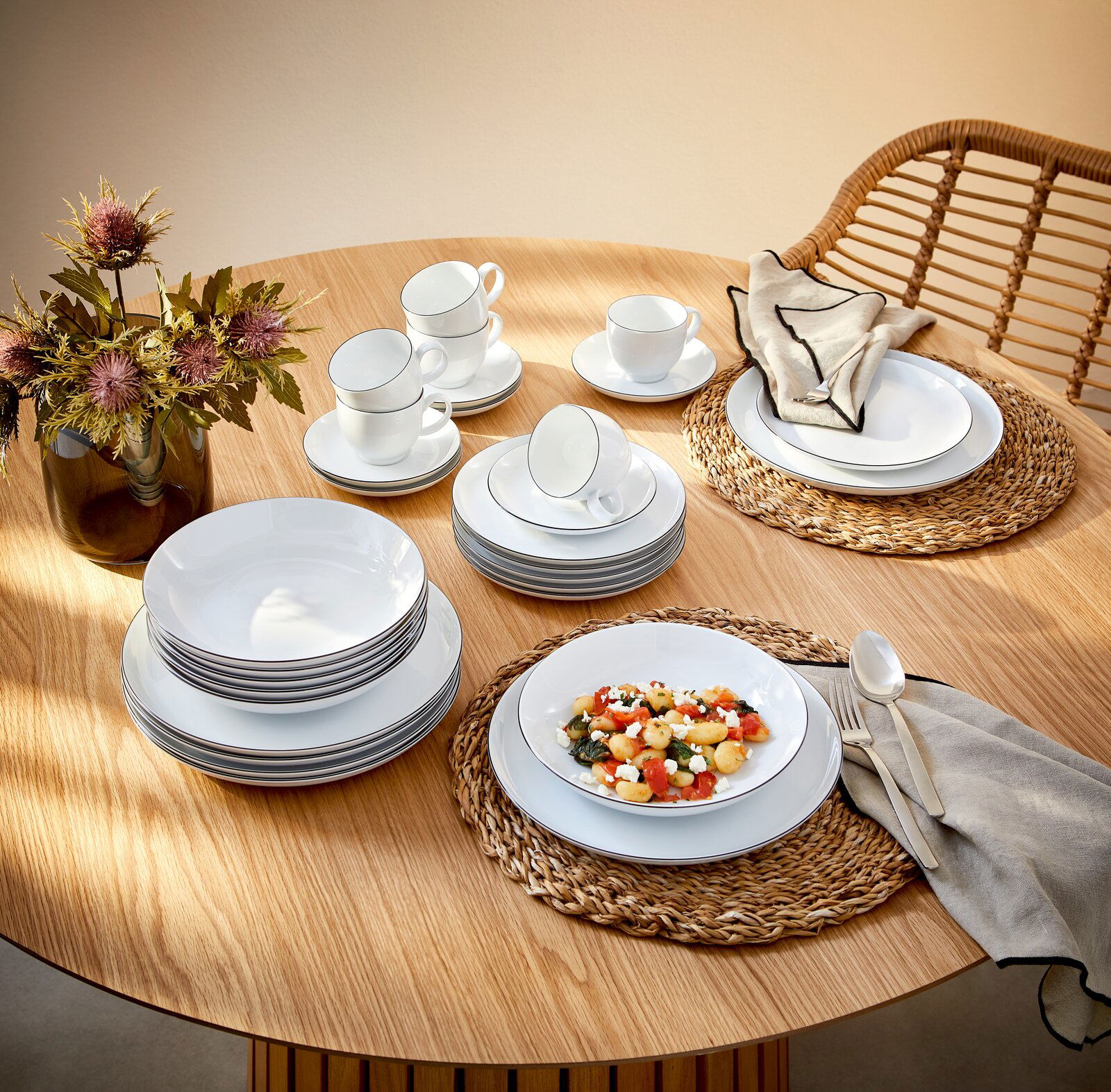 Seltmann Weiden Kombiservice 30-tlg. LIDO Elegantes Kombiservice Lido Black 30-teilig auf einem Holztisch, bestehend aus Tellern, Tassen und Schalen, mit einer modernen Tischdekoration aus Blumen und geflochtenen Platzsets, aus der Vogelperspektive fotografiert.