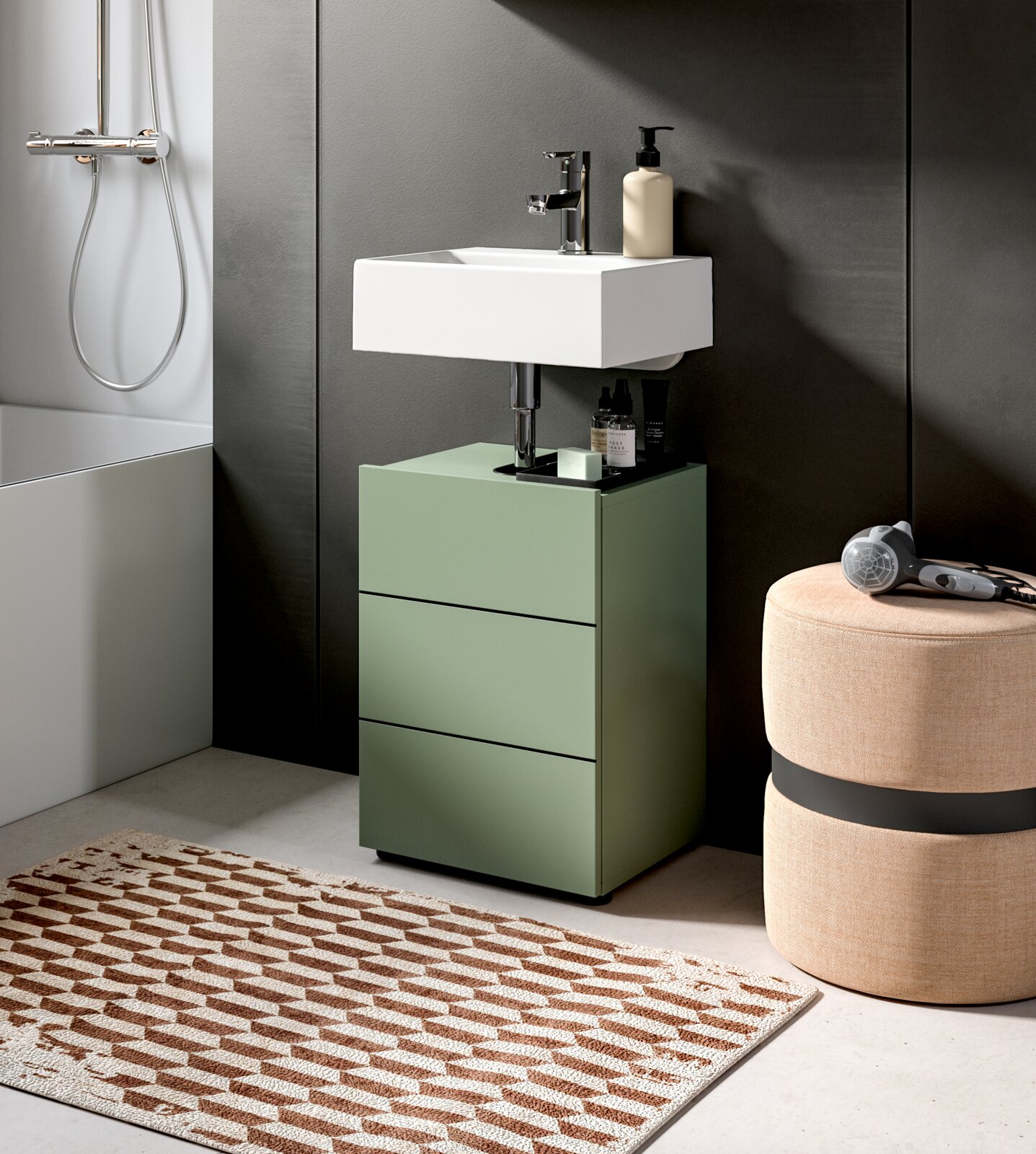 Modernes Badmöbel-Set: grüner Unterschrank mit drei Schubladen und weißem Aufsatzwaschbecken mit Chromarmatur, fotografiert in leichter Seitenansicht von vorn.