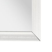 Nahaufnahme eines rechteckigen Spiegels mit weißem, verziertem Rahmen, perspektivisch von der Ecke aufgenommen.