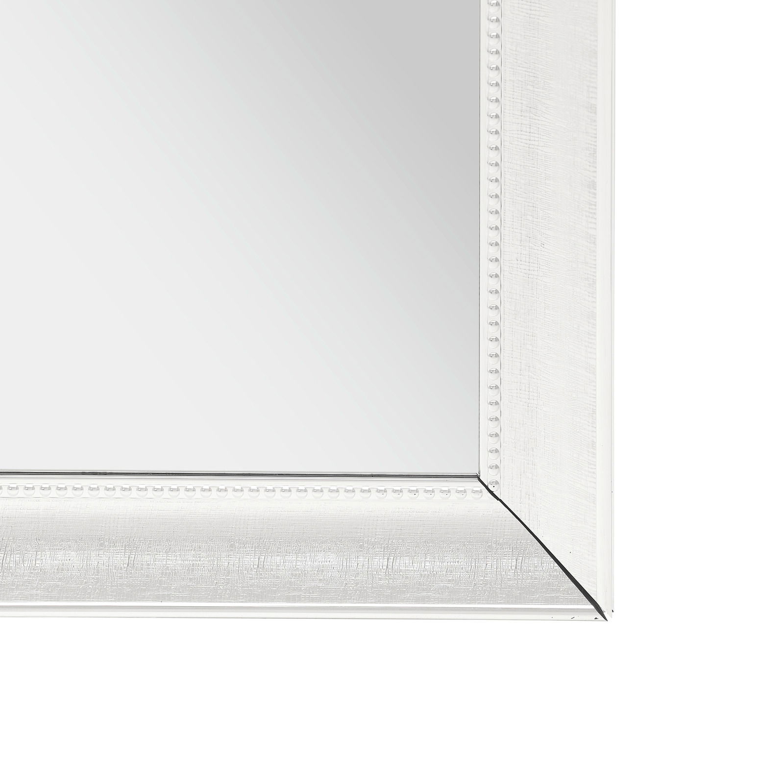 Nahaufnahme eines rechteckigen Spiegels mit weißem, verziertem Rahmen, perspektivisch von der Ecke aufgenommen.
