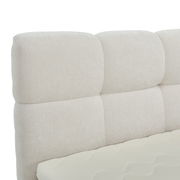 Nahaufnahme eines gepolsterten, cremefarbenen Boxbett-Kopfteil mit weicher Textur, seitliche Perspektive