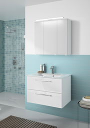 Moderner weißer Badblock mit zwei Schubladen und integriertem Waschbecken, frontal betrachtet, vor einer Wand mit blauen Fliesen.