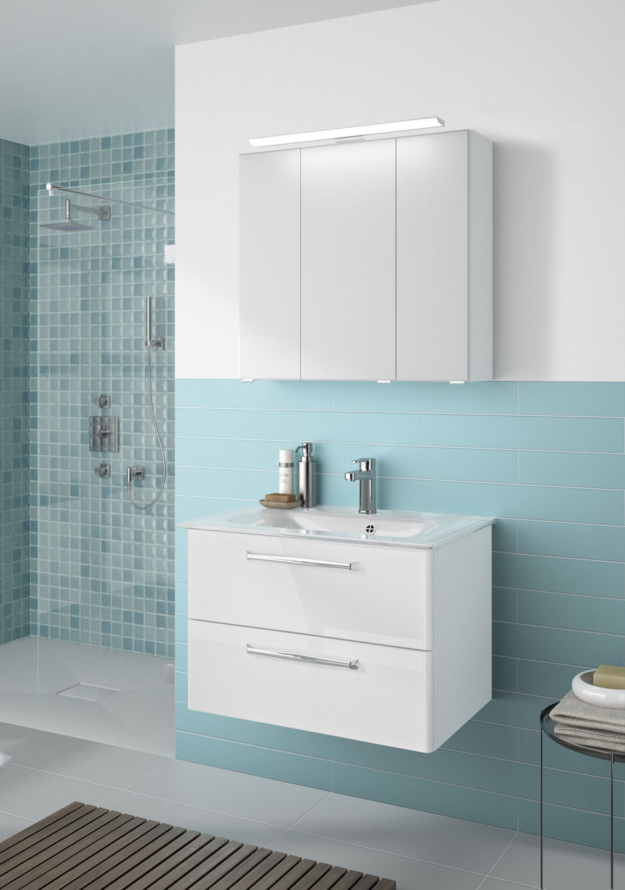 Moderner weißer Badblock mit zwei Schubladen und integriertem Waschbecken, frontal betrachtet, vor einer Wand mit blauen Fliesen.