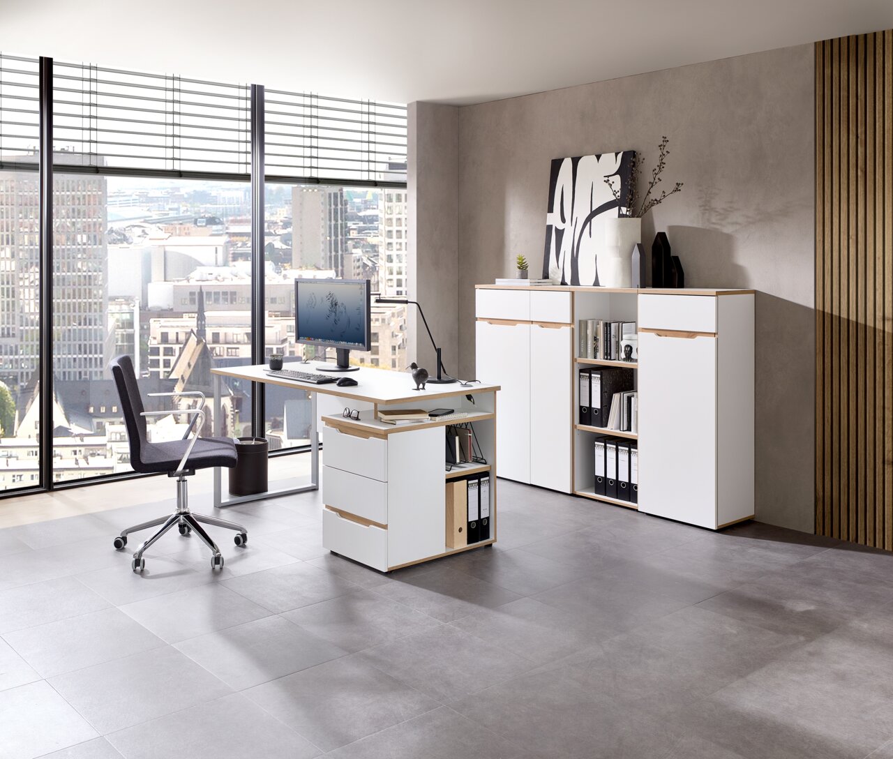 Moderne Büroumgebung mit weißem Schreibtisch, Rollcontainer und Aktenschrank, seitliche Perspektive.