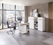 Moderne Büroumgebung mit weißem Schreibtisch, Rollcontainer und Aktenschrank, seitliche Perspektive.