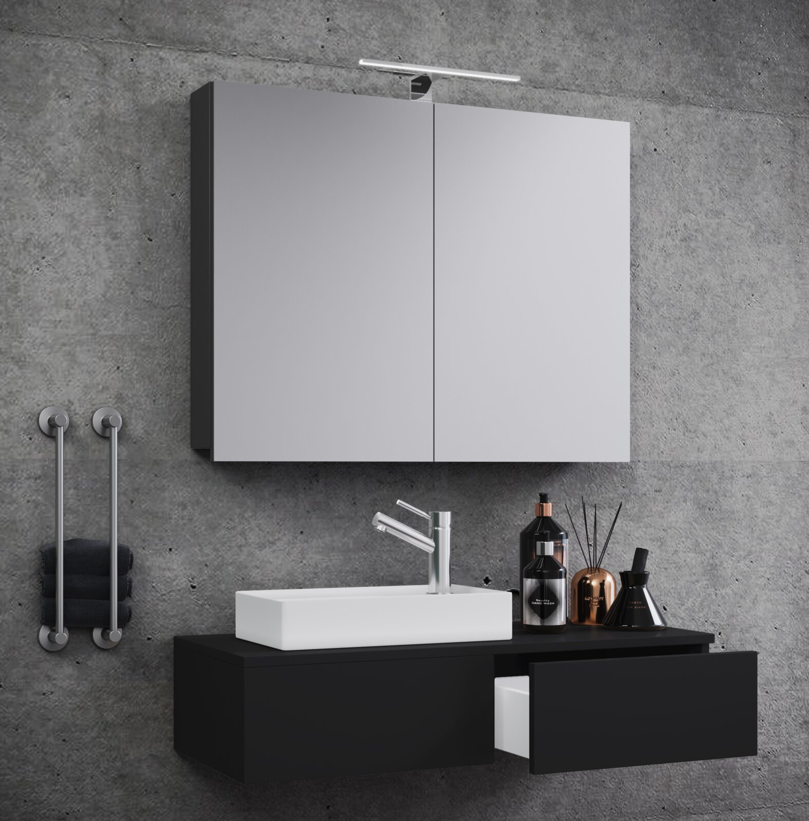 Modernes Badezimmer-Set mit beleuchtetem Spiegelschrank, weißem Aufsatzwaschbecken und schwarzem Waschtischunterschrank vor Betonwand, perspektivisch in leichter Seitenansicht von vorn