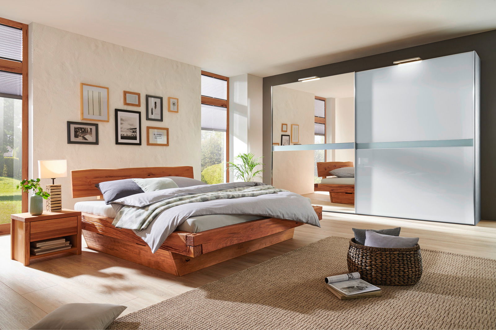 Linea Natura Bett AMAZON Modernes Schlafzimmer mit einem eleganten Holzbett und einem großen Kleiderschrank mit Schiebetüren, seitliche Perspektive.