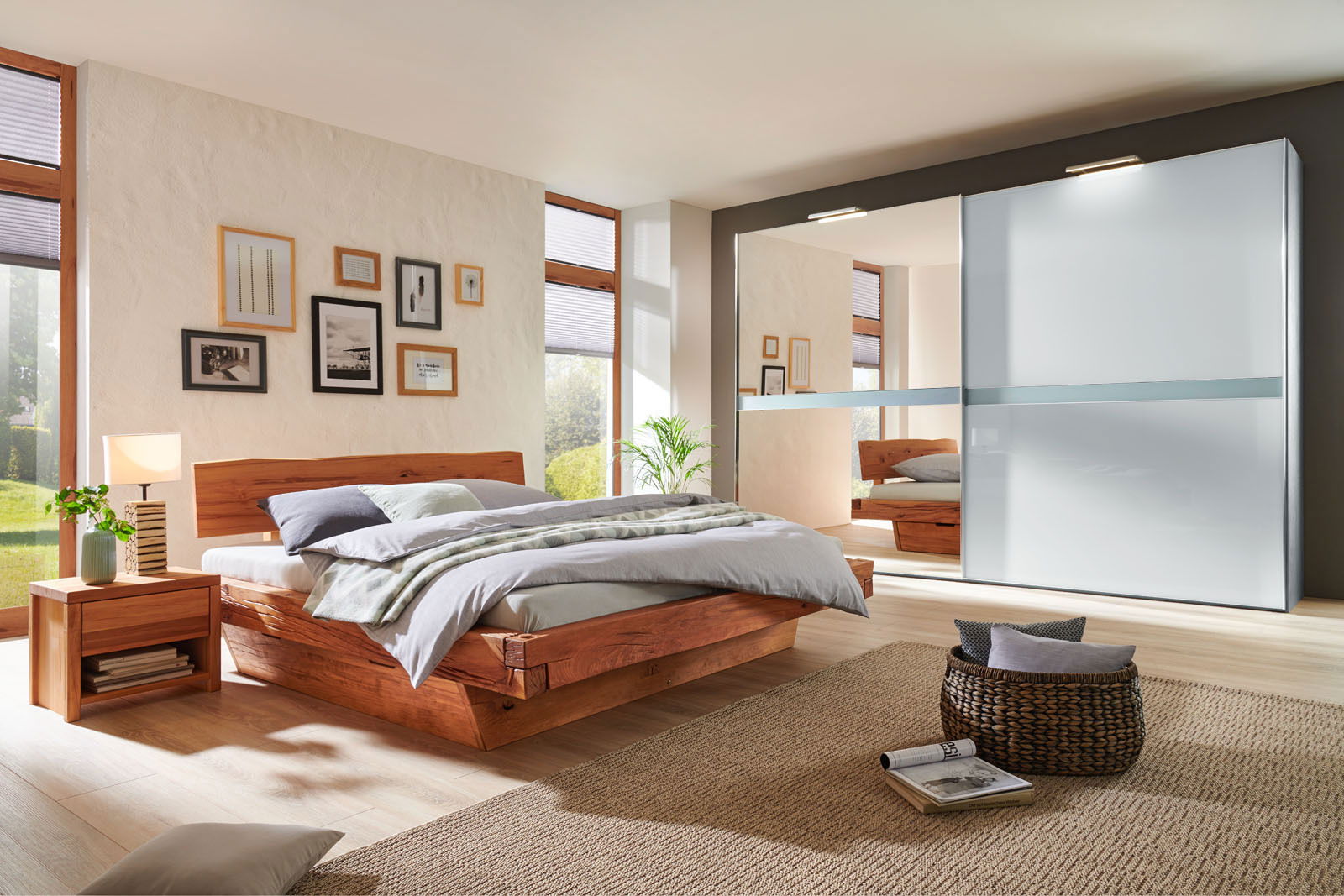 Modernes Schlafzimmer mit einem eleganten Holzbett und einem großen Kleiderschrank mit Schiebetüren, seitliche Perspektive.