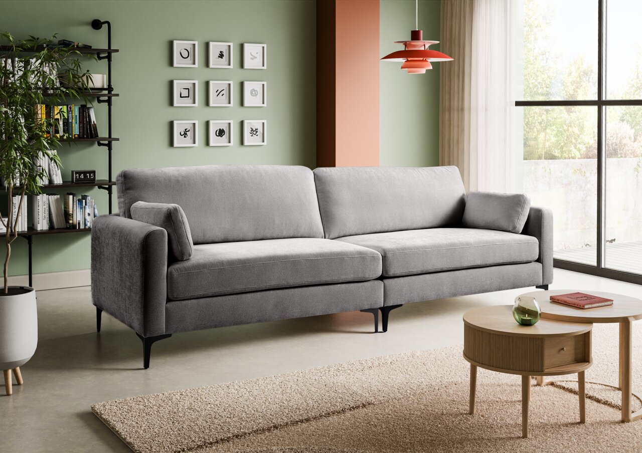MID.YOU Sofa 4-Sitzer VENTI Modernes graues 3-Sitzer-Sofa mit Stoffbezug, breiten Armlehnen und schwarzen Metallfüßen im Wohnzimmer; Perspektive: frontale Ansicht leicht von links.