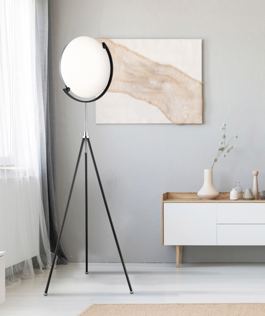 Moderne LED-Stehleuchte mit rundem, weißem Lampenschirm auf einem dreibeinigen schwarzen Stativ, seitliche Perspektive im Wohnzimmer.