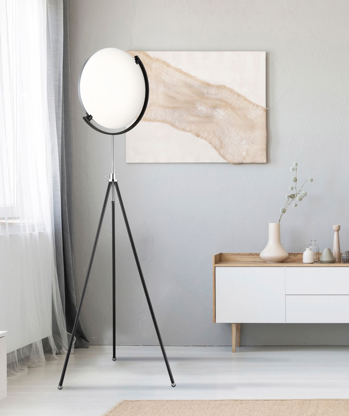 Moderne LED-Stehleuchte mit rundem, weißem Lampenschirm auf einem dreibeinigen schwarzen Stativ, seitliche Perspektive im Wohnzimmer.
