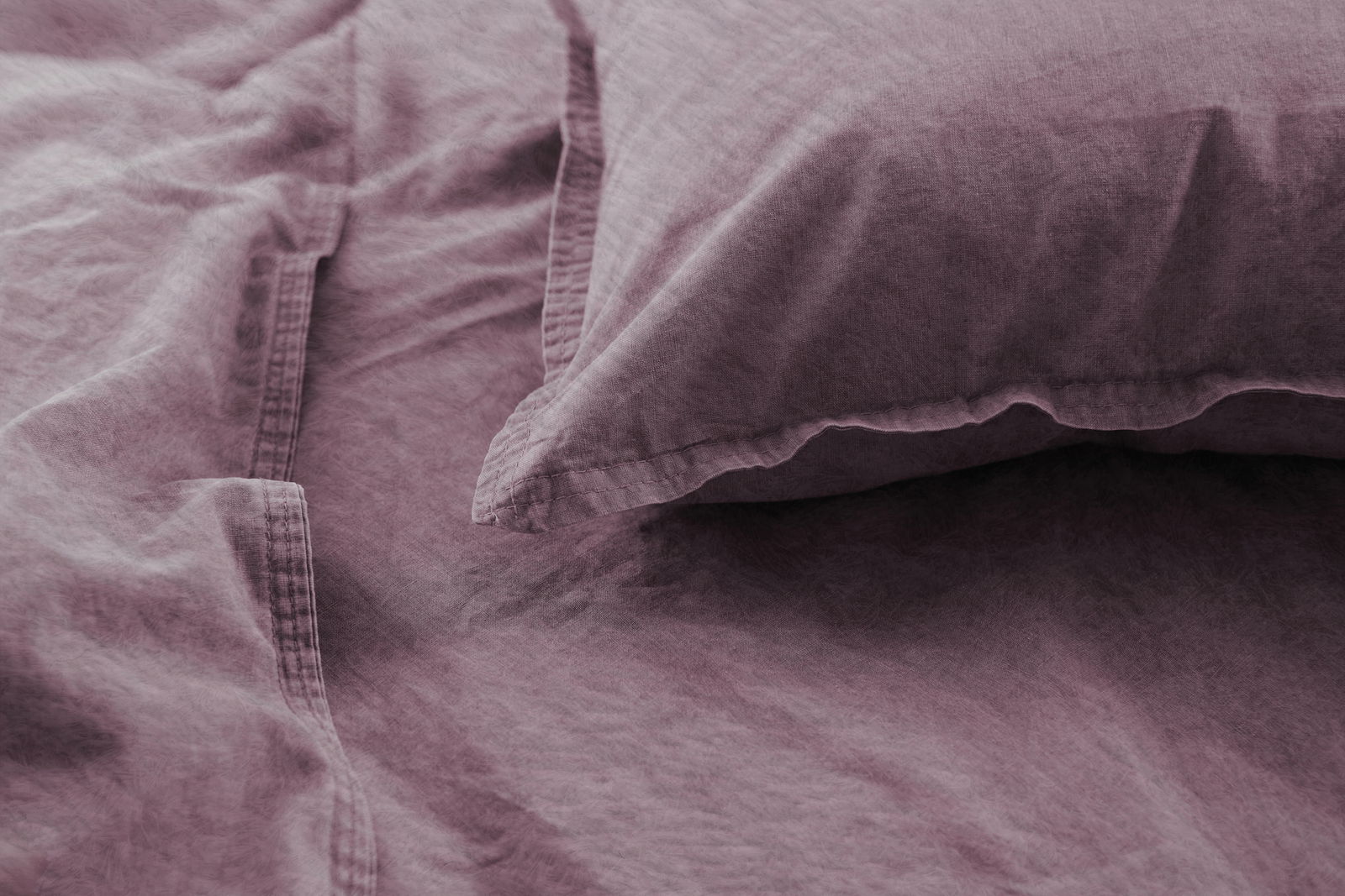 Nahaufnahme von lila Bettwäsche mit Kissenbezug, weiche Textur