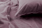Nahaufnahme von lila Bettwäsche mit Kissenbezug, weiche Textur