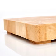 Nahaufnahme eines massiven Hackblocks aus Holz mit glatter Oberfläche und abgerundeten Ecken, seitliche Perspektive.