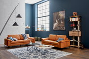 Moderner Couchtisch in einem stilvollen Wohnzimmer mit Ledersofas und dekorativen Elementen, seitliche Perspektive.