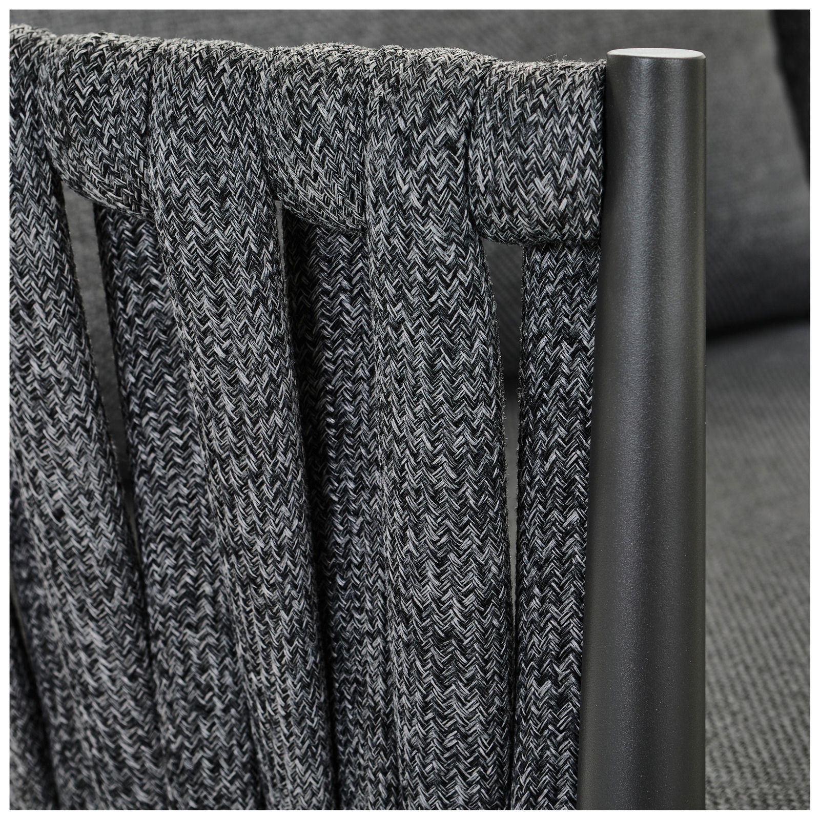 Detailansicht eines Loungesessels mit geflochtenem Stoff und Metallrahmen.