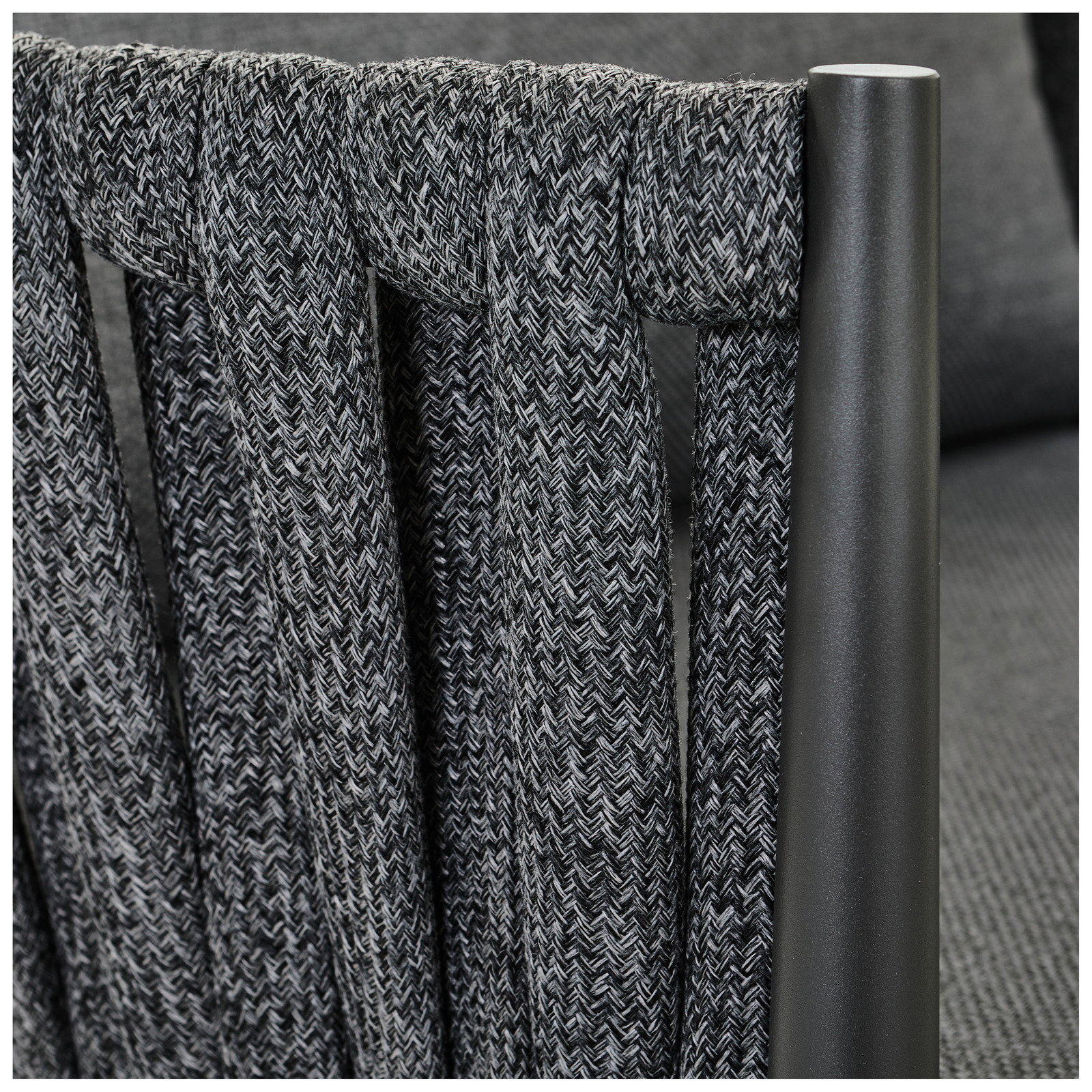 Detailansicht eines Loungesessels mit geflochtenem Stoff und Metallrahmen.