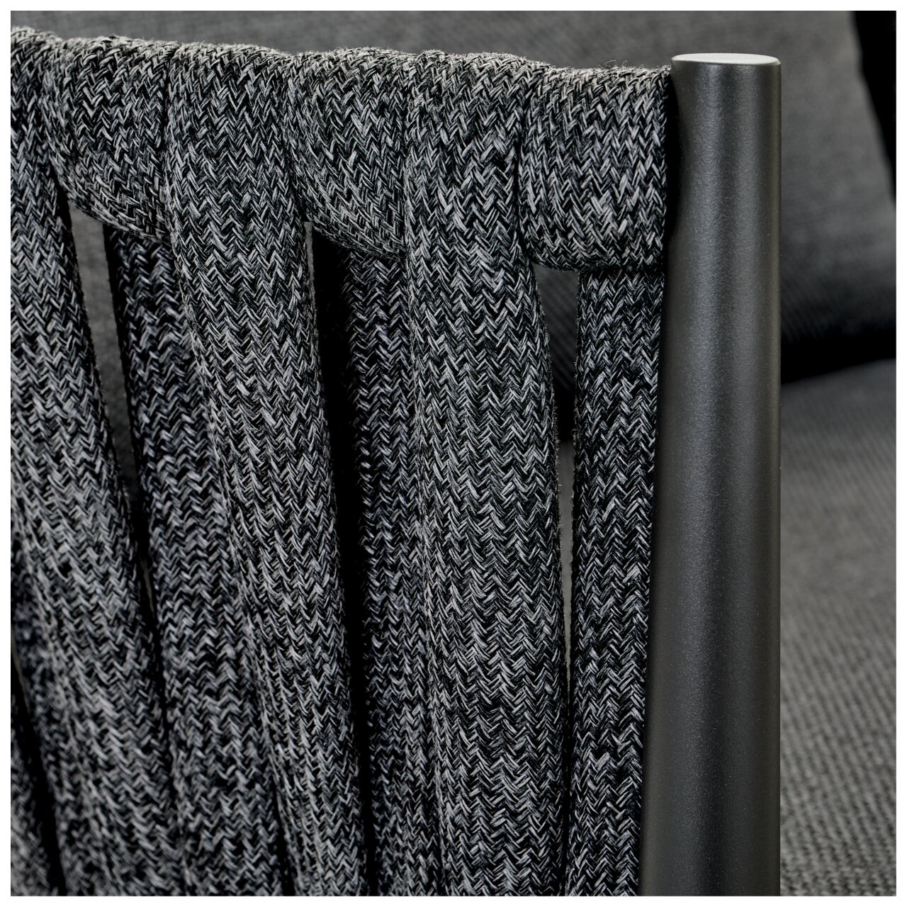 Detailansicht eines Loungesessels mit geflochtenem Stoff und Metallrahmen.