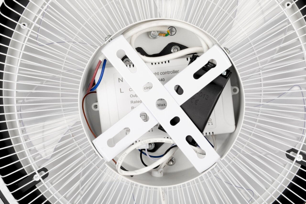 Nahaufnahme der Rückseite eines Deckenventilators mit sichtbaren Kabeln und Befestigungselementen, von unten betrachtet.