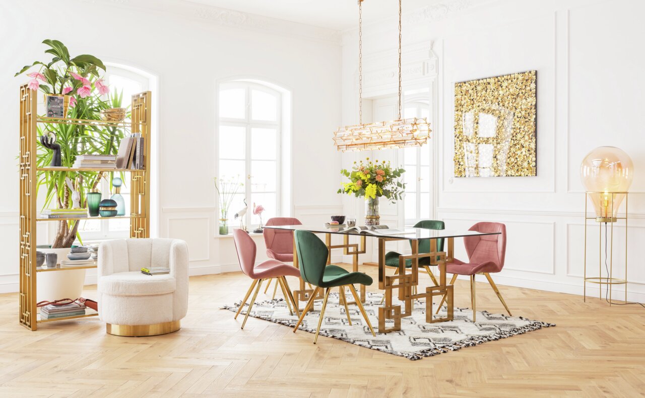 Esszimmer mit modernem Design: Ein eleganter Tisch mit goldenen Beinen und Glasplatte, umgeben von grünen und rosa Stühlen. Perspektive von vorne.