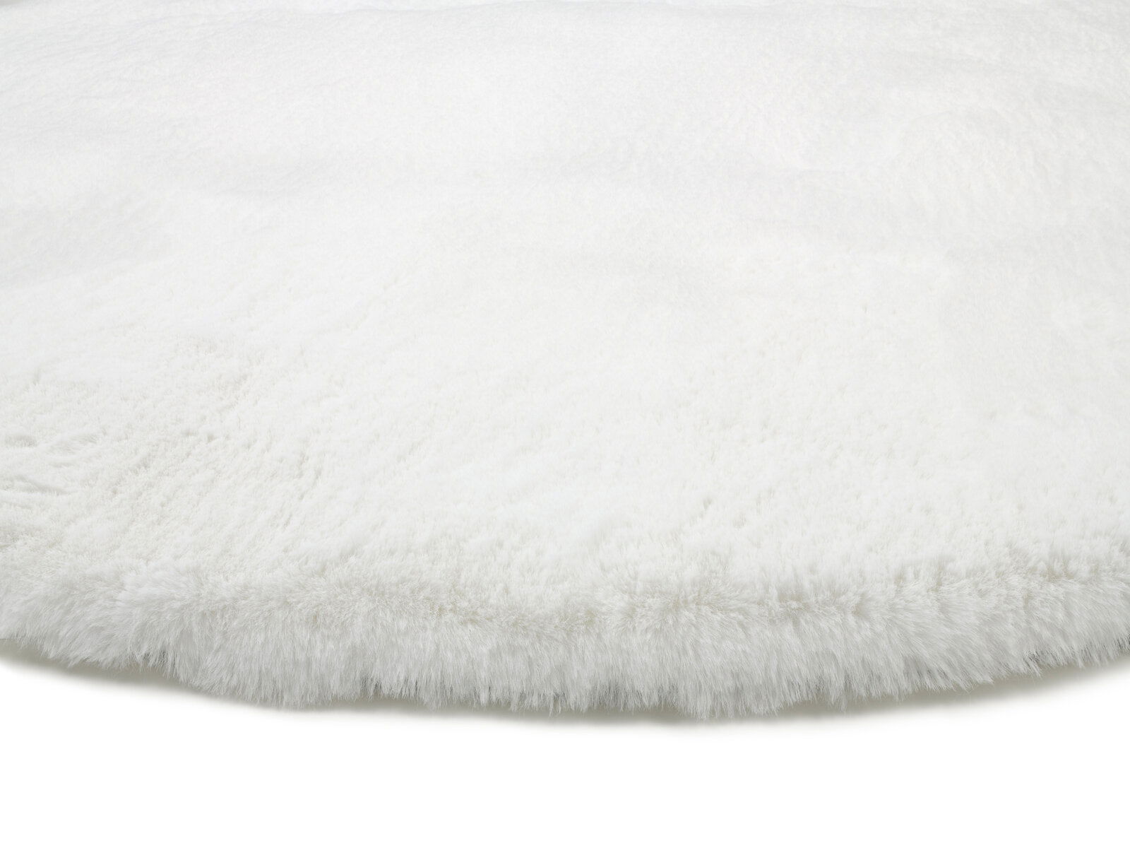 Nahaufnahme eines weißen, flauschigen Fellteppichs aus seitlicher Perspektive.