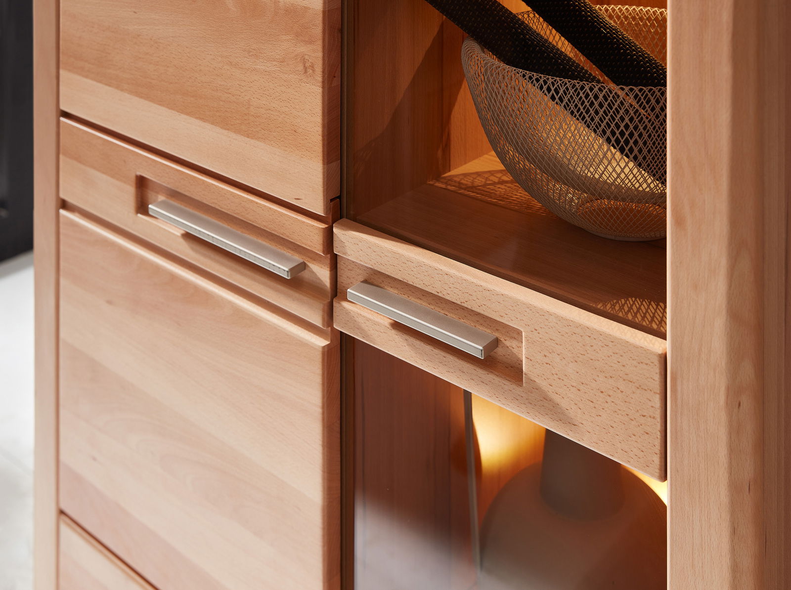 Nahaufnahme einer hölzernen Vitrine mit modernen Metallgriffen, seitliche Perspektive.