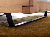 Nahaufnahme eines Balkenbetts aus Holz mit schwarzem Metallgestell, seitliche Perspektive.