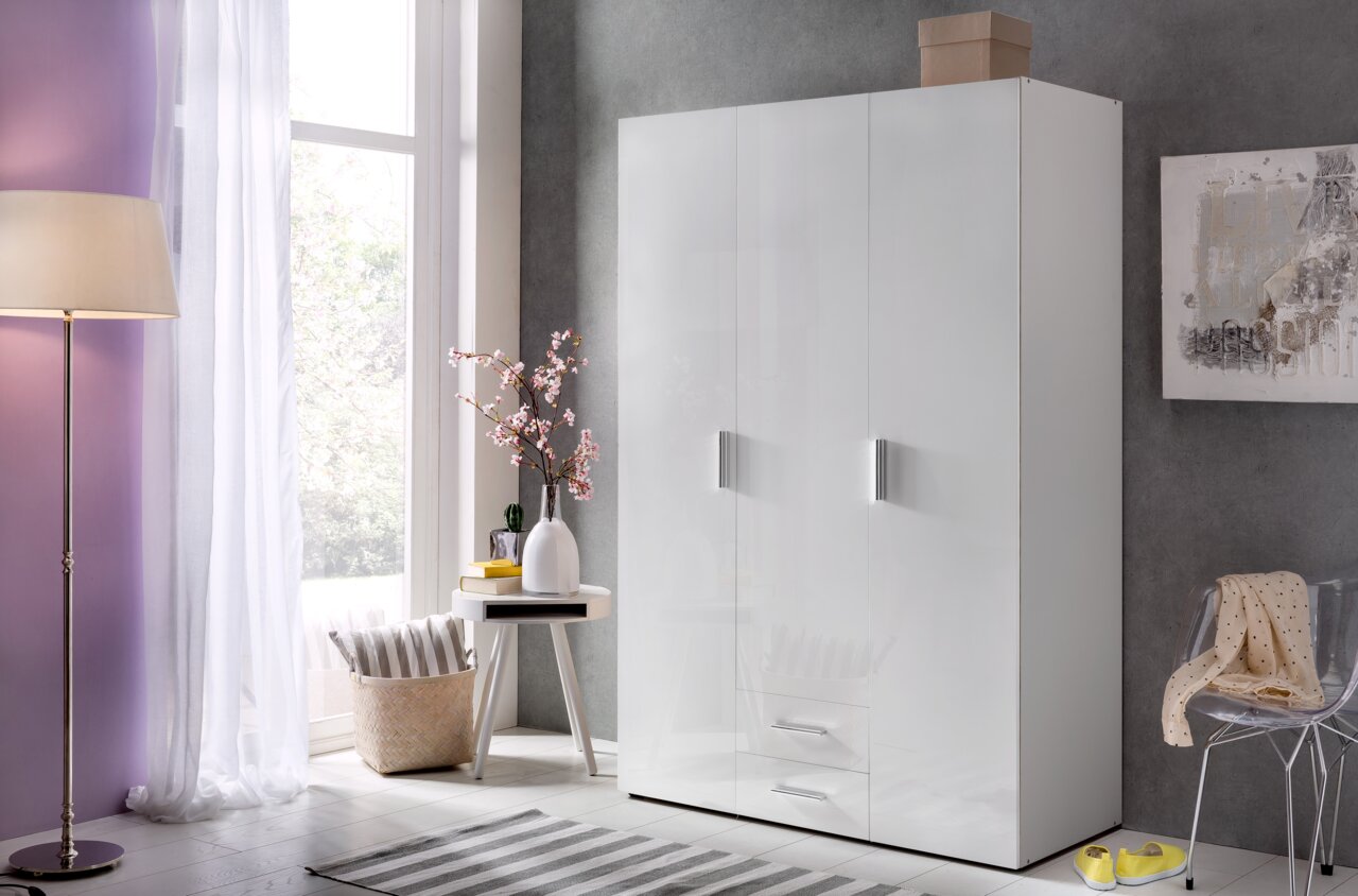 Moderner weißer Kleiderschrank mit Hochglanzoberfläche, zwei Türen und zwei Schubladen, in einem stilvoll eingerichteten Raum mit seitlicher Perspektive.