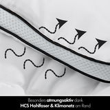 Nahaufnahme einer atmungsaktiven Winterbettdecke mit HCS Hohlfaser und Klimanetz am Rand, von der Seite betrachtet.