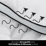 Nahaufnahme einer atmungsaktiven Winterbettdecke mit HCS Hohlfaser und Klimanetz am Rand, von der Seite betrachtet.