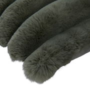 Nahaufnahme einer flauschigen, dunkelgrünen Fellkissenhülle in diagonaler Perspektive.
