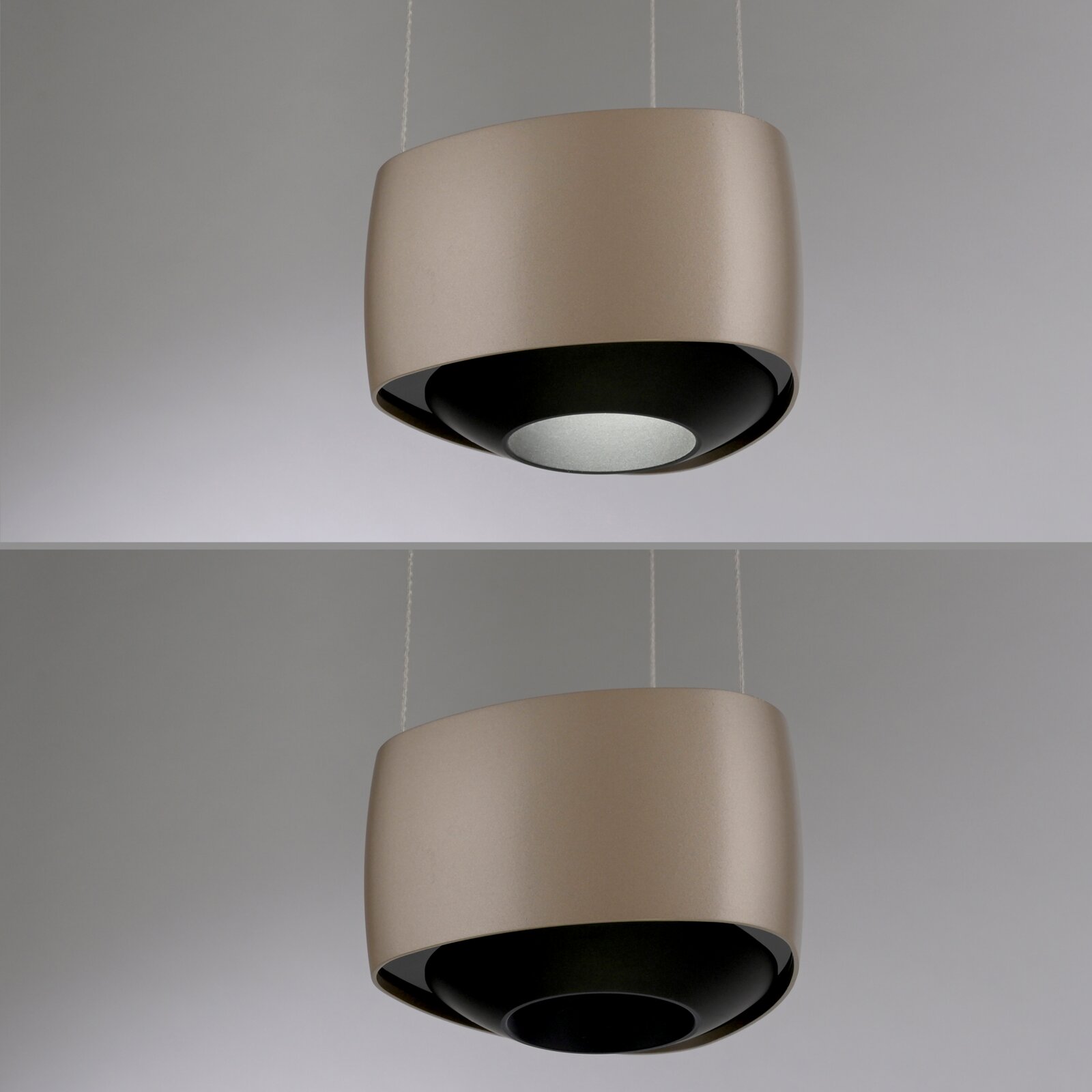 Moderne zylindrische Pendelleuchte in Beige mit schwarzer Innenseite und rundem Diffusor, hängend an zwei Kabeln, schräg von unten fotografiert