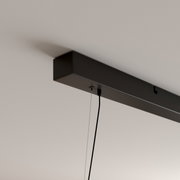 Zwarte, rechthoekige plafondbevestiging van een hanglamp met zichtbare kabel en ophanging, gefotografeerd vanuit een schuin onderaanzicht.