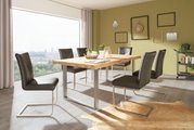 Moderne Esszimmeransicht mit einem großen Holztisch und sechs schwarzen Stühlen, seitliche Perspektive.